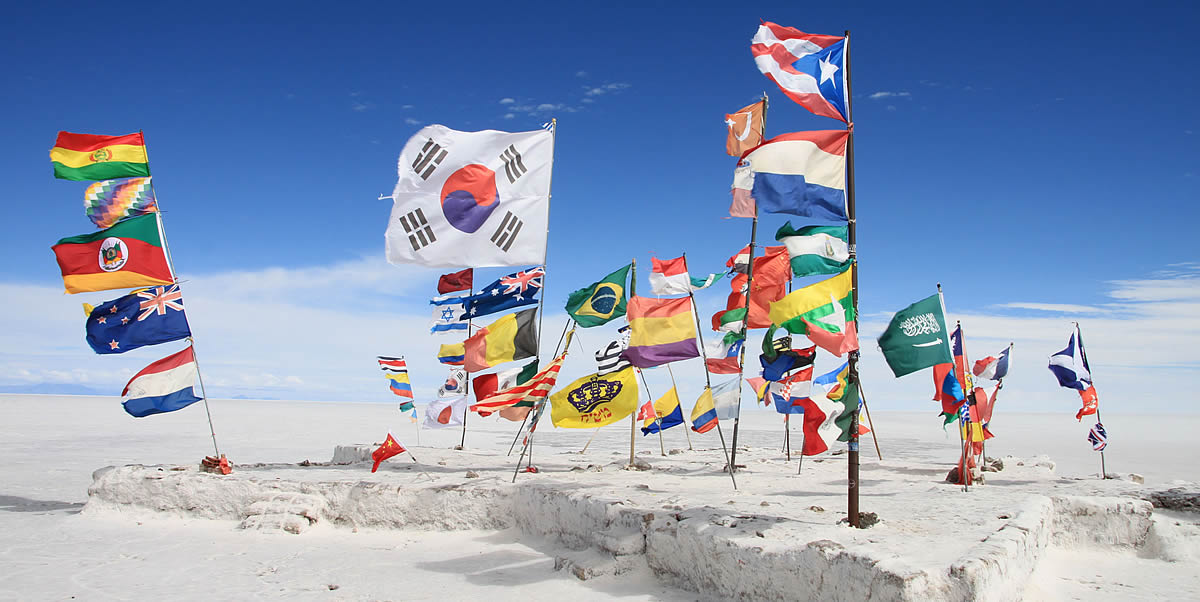 Country Pages Methodology, National flags waving on the Uyuni Salt Flats in Bolivia, showcasing global diversity