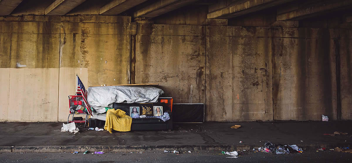 Poverty in the United States, A gritty urban underpass in Philadelphia with signs of homelessness and American flag.