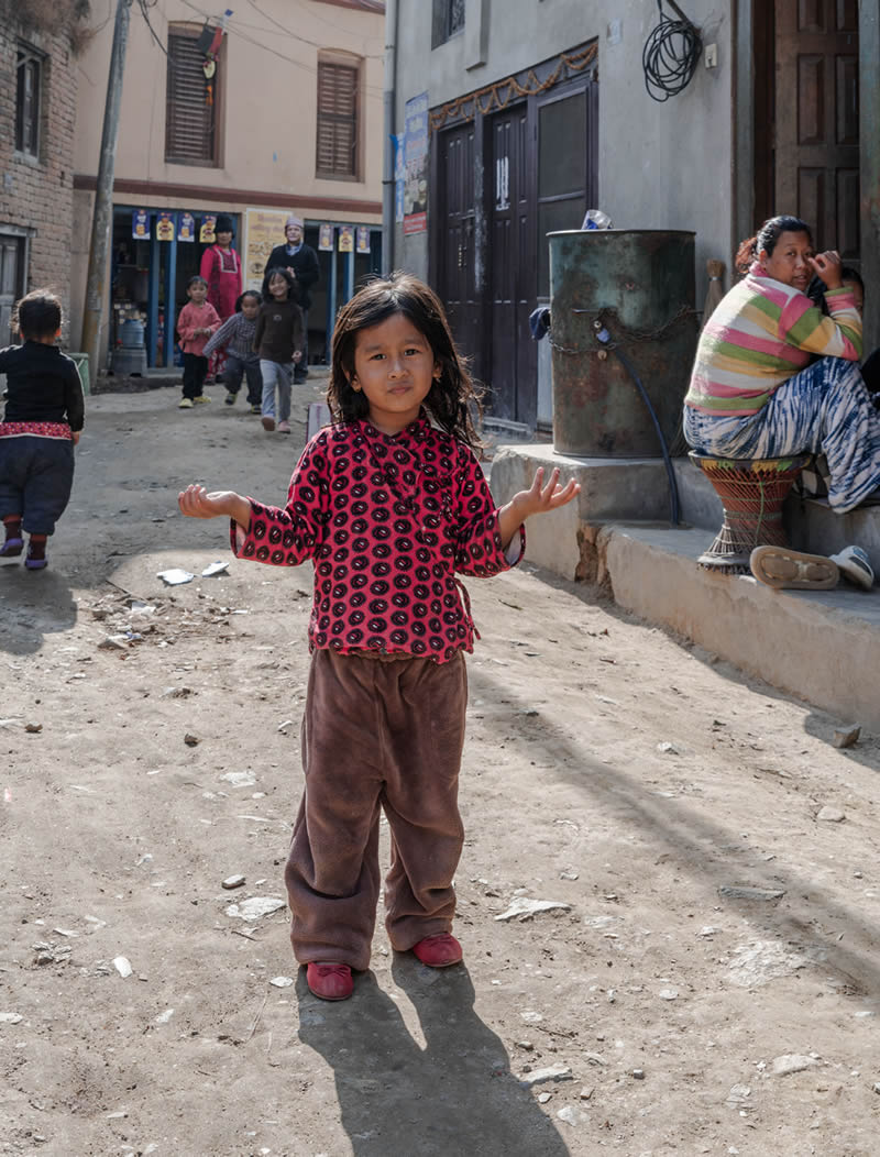VAWG Nepal, a young girl stands confidently in a vibrant Kathmandu street, surrounded by local community life